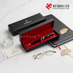 Bút ký tên cao cấp khắc logo Vingroup đặt trong hộp quà tặng sang trọng lót nhung đỏ cùng sổ tay da và kính mắt vàng trên nền đá cẩm thạch trắng đẳng cấp.